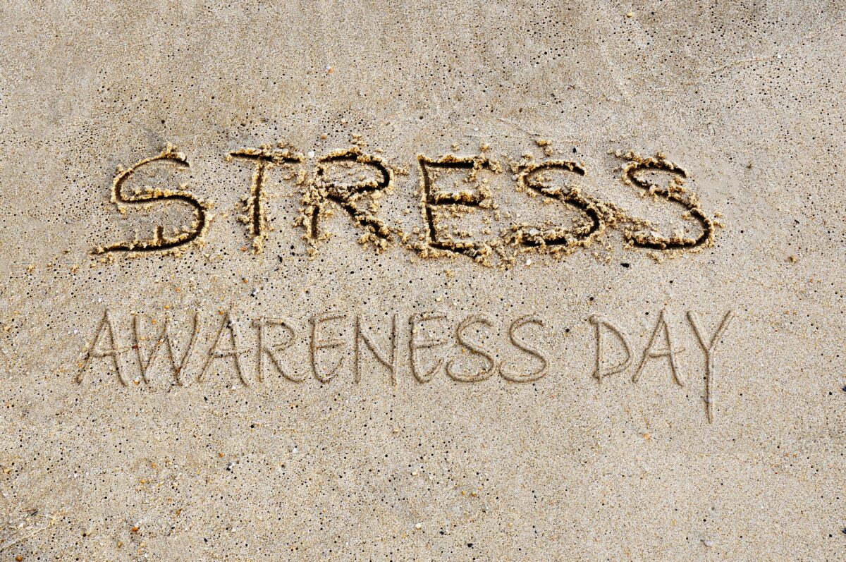 Stress Awareness Day written in the sand